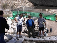 a group of people standing in front of a stone wall